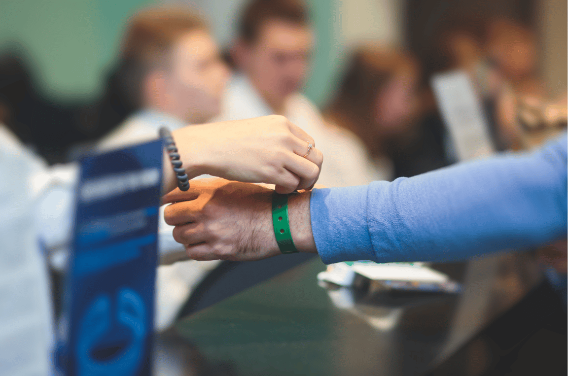 Someone putting on someone else's' wristband.